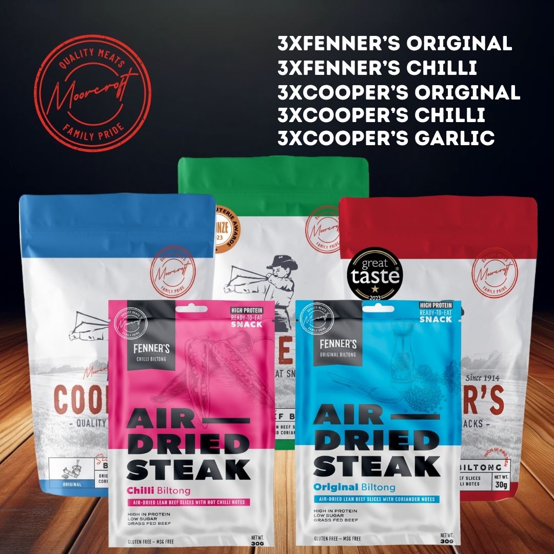 A collection of air-dried meat snacks from Fenner's and Cooper's is displayed. There are three varieties of Fenner's Biltong: Original, Chilli, and a packet of Cooper's Biltong in Original, Chilli, and Garlic flavours. Each packet has a distinct colour at the top—blue, pink, and green—indicating different flavours, all bearing the 'Great Taste 2023' award seal.