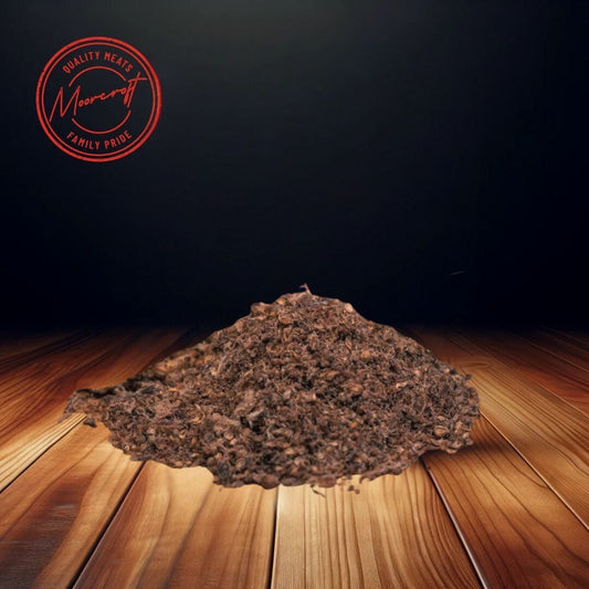 A mound of Fenner’s Original Biltong Powder is centred on a wooden surface, set against a dark background that emphasizes the texture of the finely ground meat. This high-protein seasoning is ideal for adding a rich, savory flavour to dishes, carrying the Moorcroft Family Pride assurance of quality British produce.